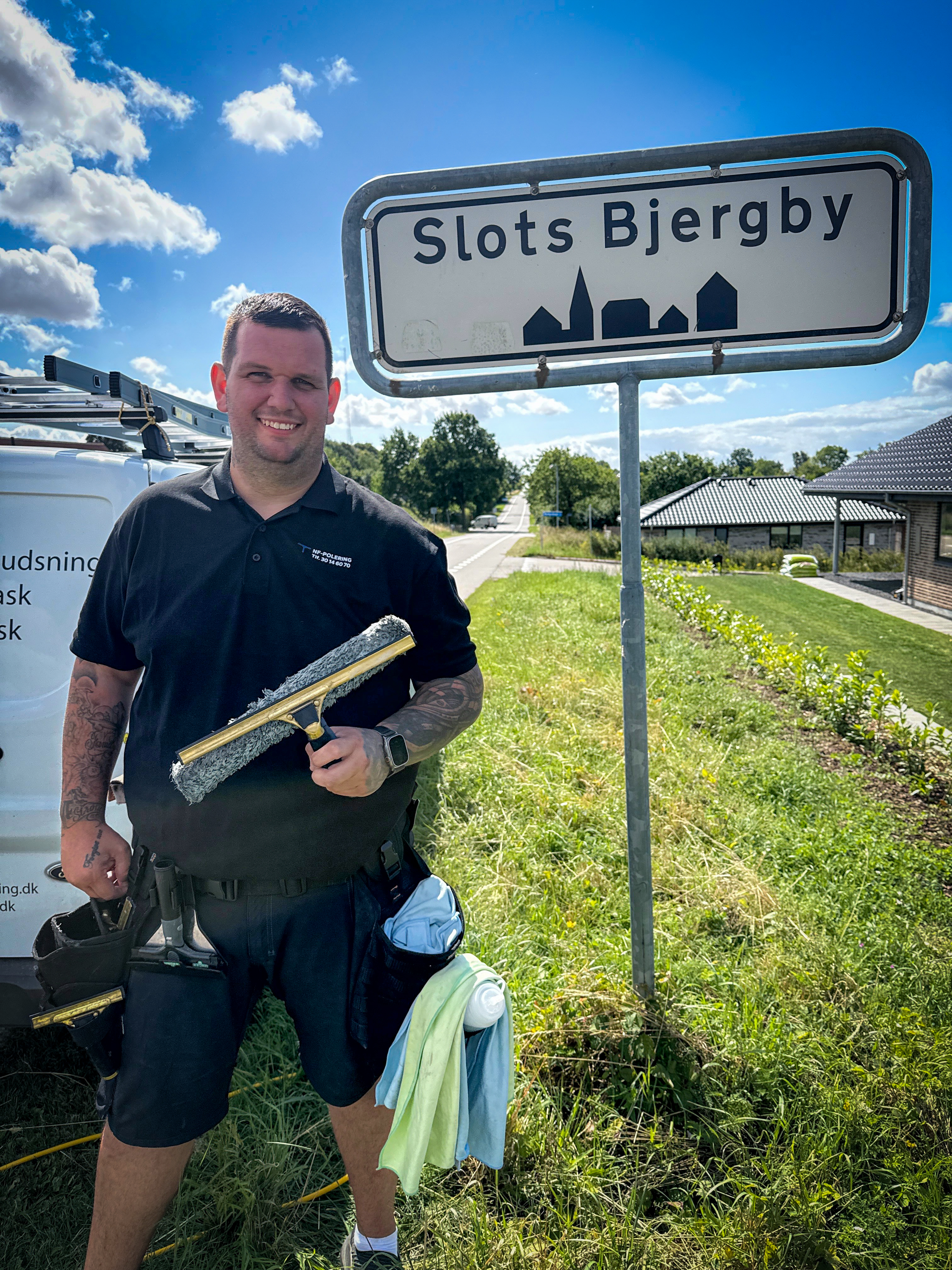 Professionel vinduespudser ved Slots Bjergby byskilt – NF Polering