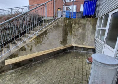 Hjørnebænk på betonvæg udendørs