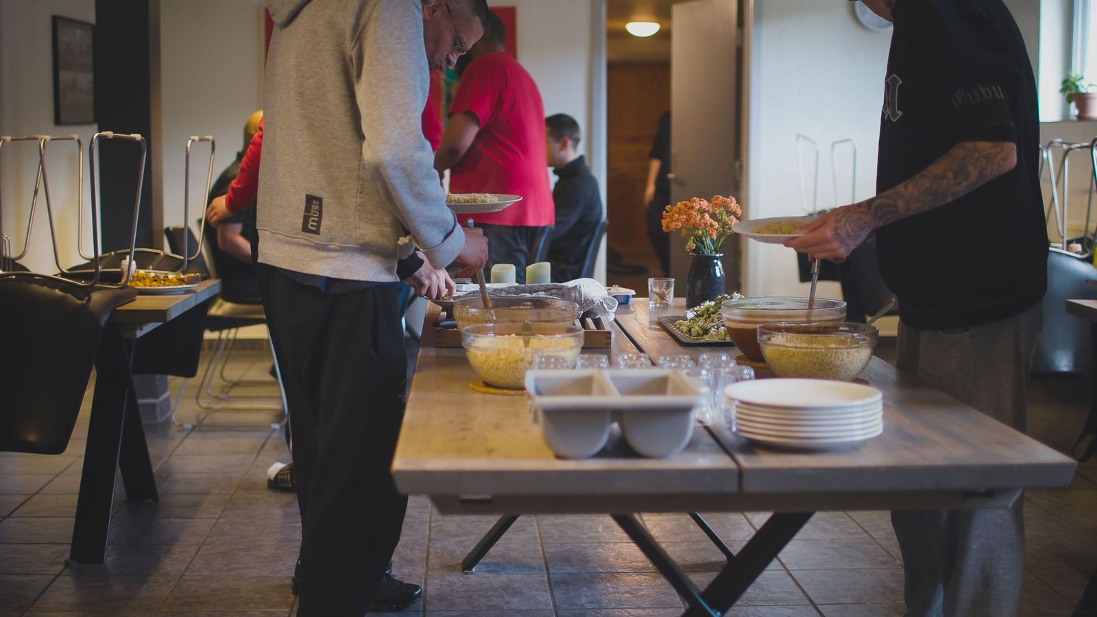 Personer forsyner sig med mad fra en anrettet buffet ved et spisebord