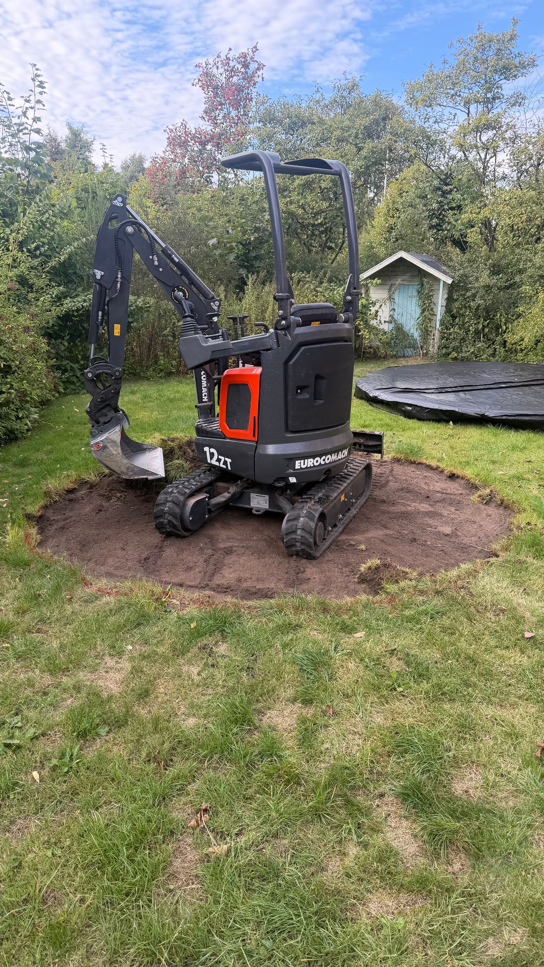 Færdigmonteret in-ground trampolin i niveau med græsplæne i have