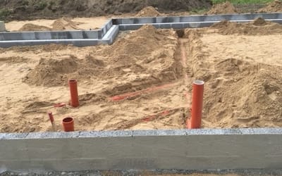 Færdigstøbt betonfundament og sokkel med kloakrør og klargjort sandpude