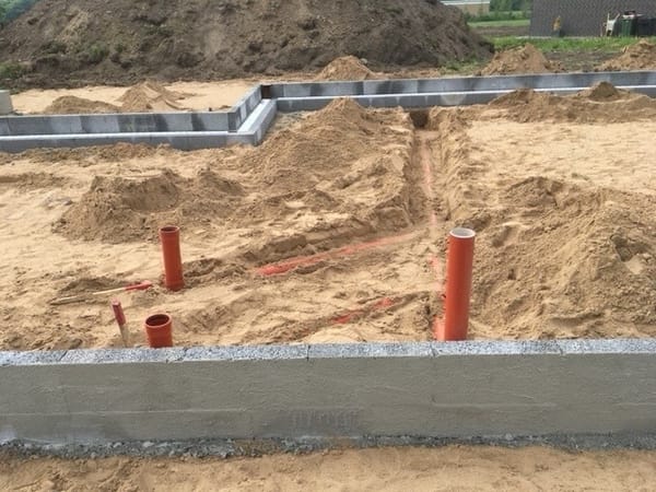 Færdigstøbt betonfundament og sokkel med kloakrør og klargjort sandpude