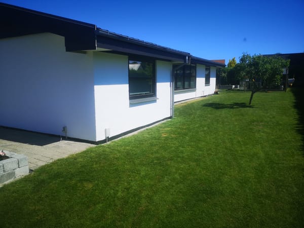 Moderne hvidt hus med stor grøn have