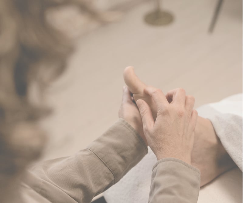 Behandler der udfører zoneterapi og fodmassage