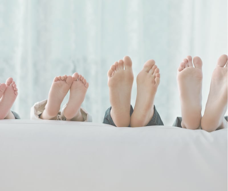 Bare fødder i hvid seng - Zoneterapi for hele familien